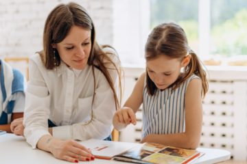 a woman and a girl reading a book